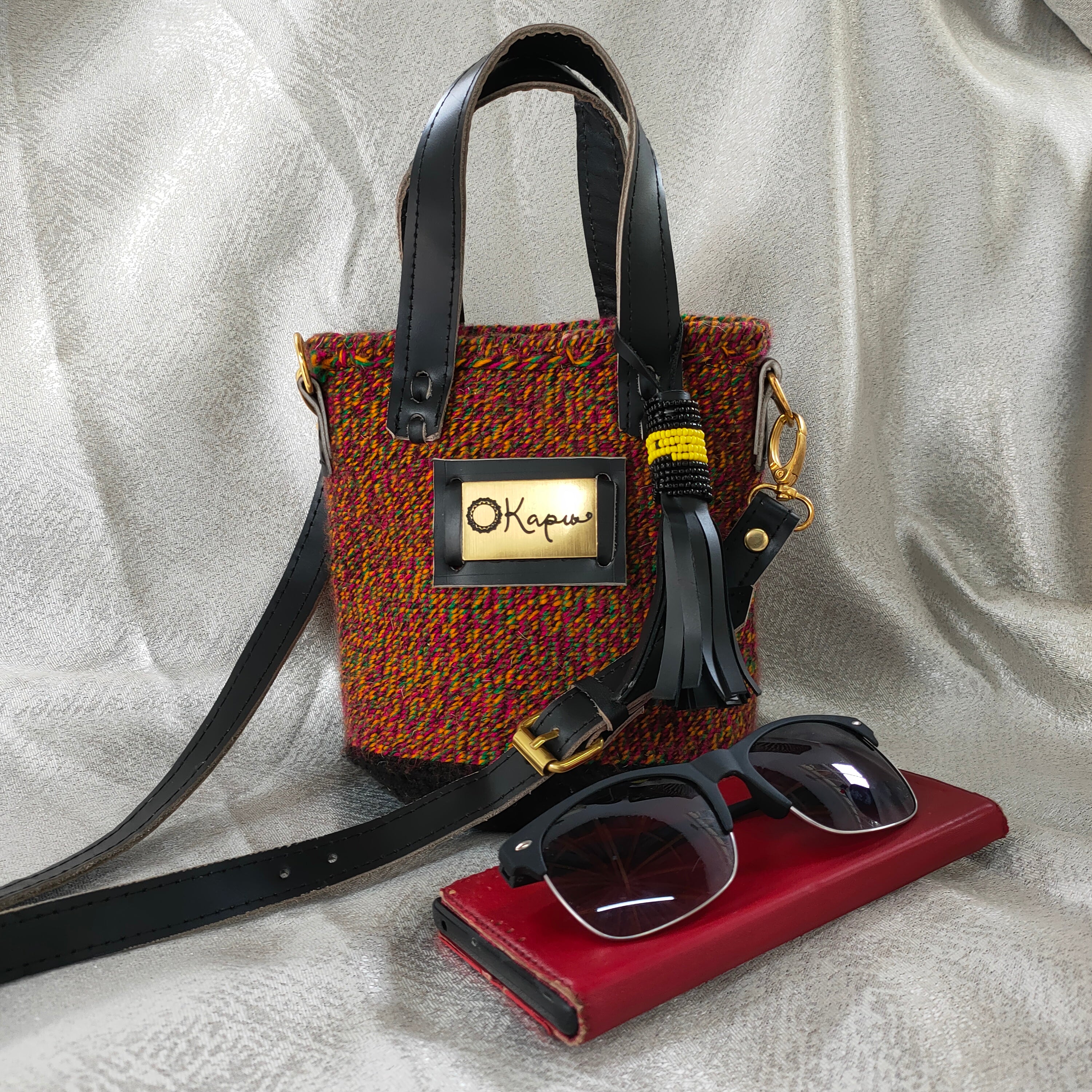 The small size of this stunning Okapu bag makes it an excellent 'going out' companion. A multi-colored piece with mostly burnt orange that says 'I am versatile and is sure to brighten the fits in your closet for both day and night activities  Its black leather trimmings include an adjustable strap to carry it over your shoulder or across your body. With the removable straps, you could just easily grab it with your hands with the top handles. 