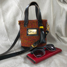The small size of this stunning Okapu bag makes it an excellent 'going out' companion. A multi-colored piece with mostly burnt orange that says 'I am versatile and is sure to brighten the fits in your closet for both day and night activities  Its black leather trimmings include an adjustable strap to carry it over your shoulder or across your body. With the removable straps, you could just easily grab it with your hands with the top handles. 