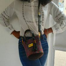 The small size of this stunning Okapu bag makes it an excellent 'going out' companion. Blue hues say 'I am cool' and this unique kiondo bag is sure to complement any of the fits in your closet, for both day and night activities.  Its black leather trimmings include an adjustable strap to carry it over your shoulder or across your body. With the removable straps, you could just easily grab it with your hands with the top handles. 